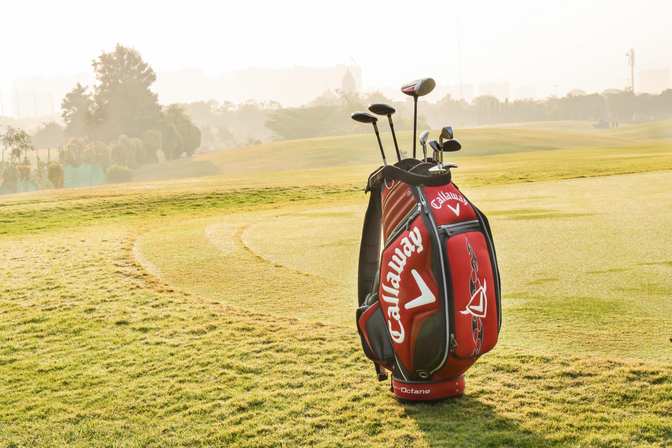 A Callaway golf bag standing on its own beside a golf green.