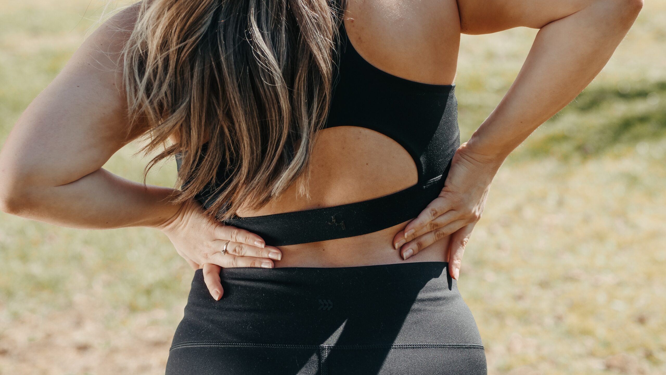 A woman holding her lower back.