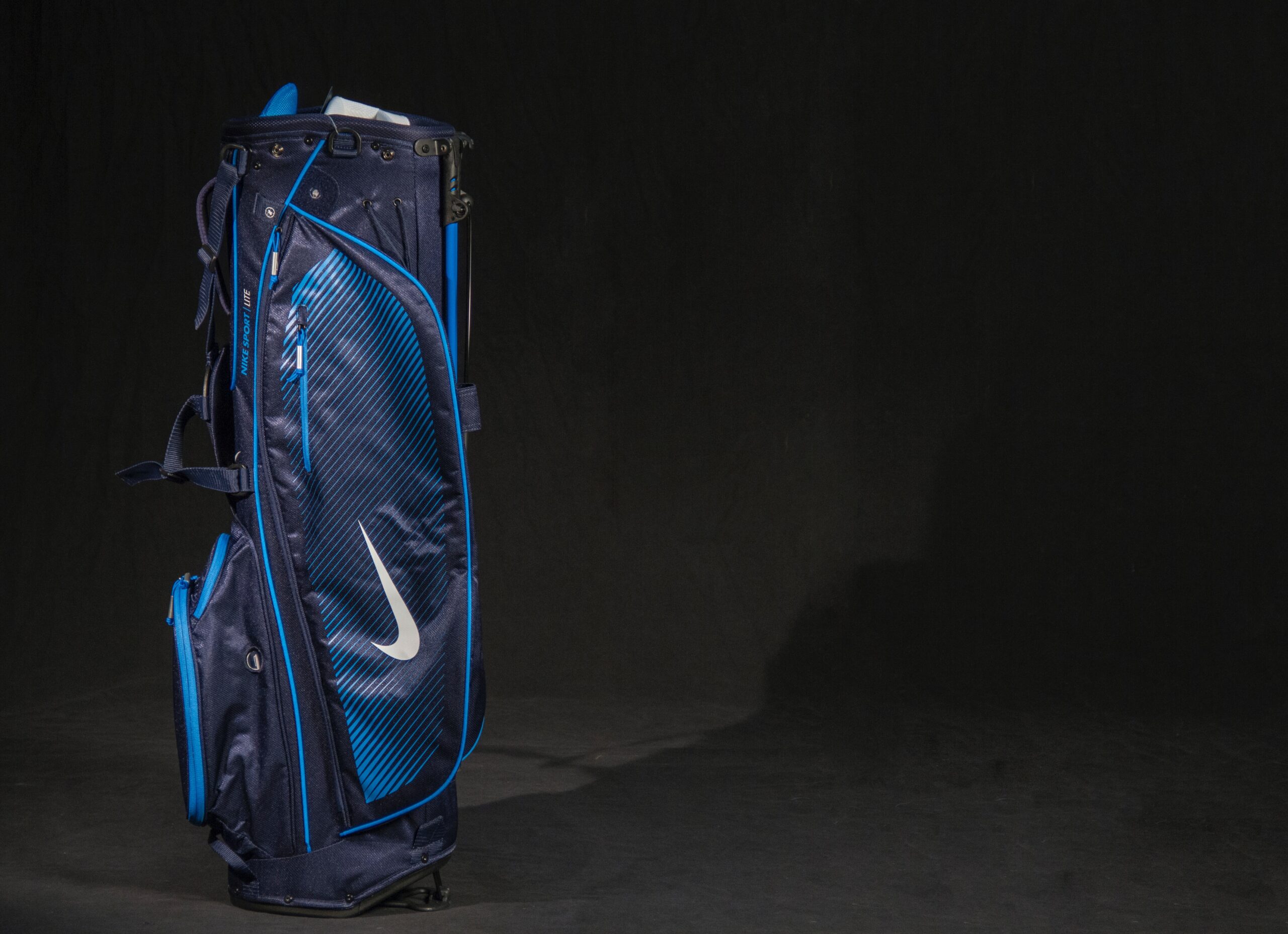 A blue Nike golf bag set against a black backdrop.